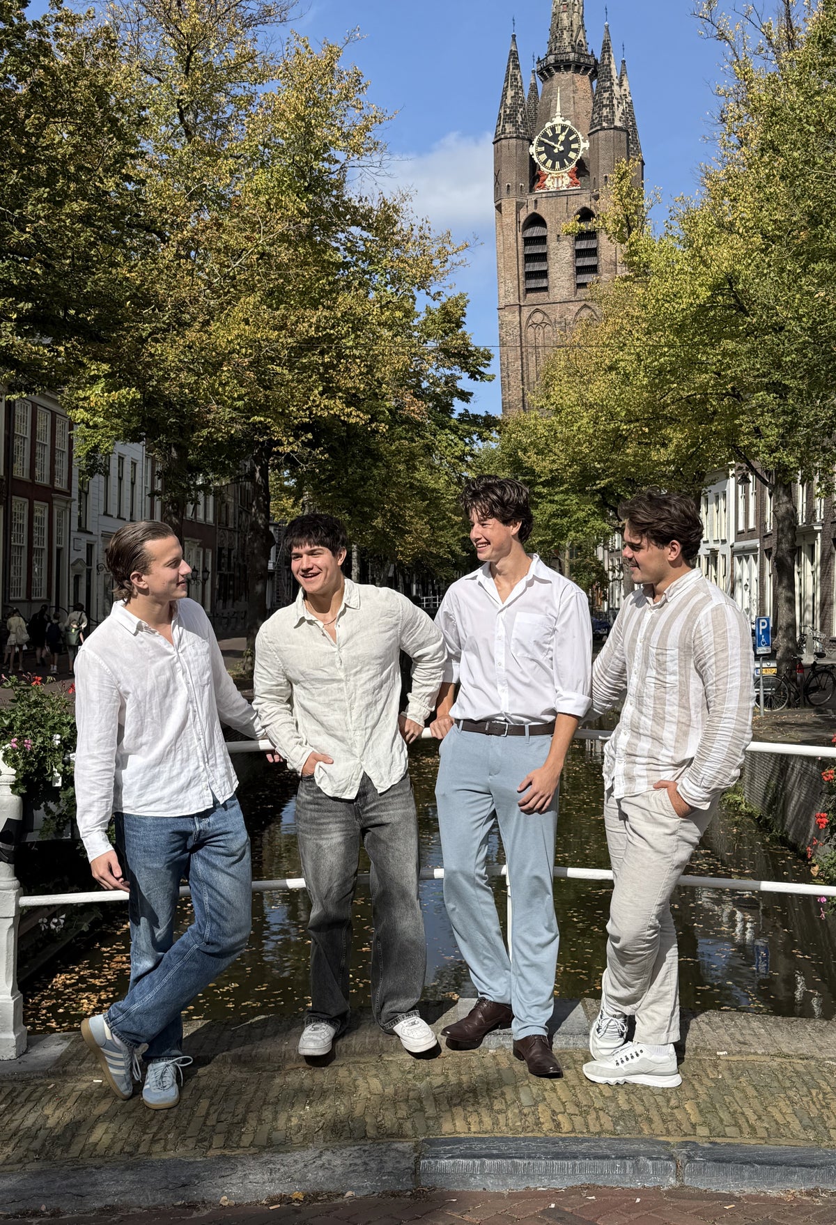 Het team achter Boxxey op een brug in Delft, met de Oude Kerk op de achtergrond